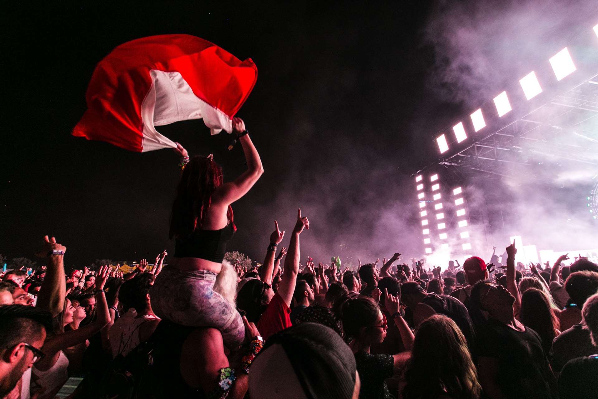A dense, energetic concert crowd filming the stage